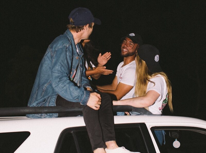 three person sitting on vehicle roof